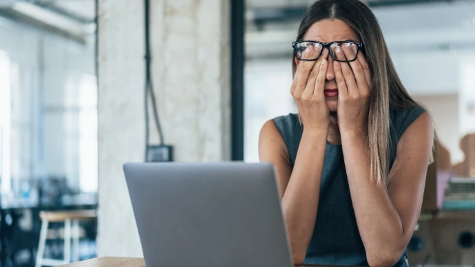 Vrouw die heel gestresseerd achter laptop zit